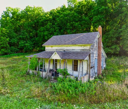 Free An old, abandoned wooden home surrounded by greenery in rural Minnesota. Stock Photo