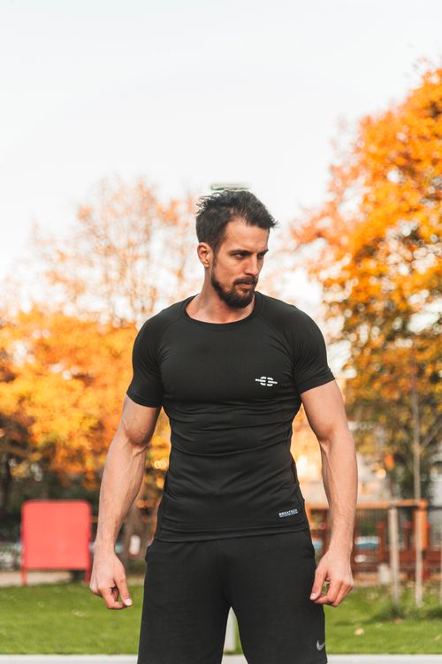 Free Muscular bearded man in sportswear posing outdoors during autumn season. Stock Photo