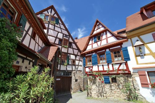Free Picturesque half-timbered houses under a clear blue sky in Germany with vibrant flowers. Stock Photo