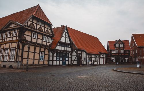 Free Scenic view of a historic village square with traditional half-timbered houses and cobblestone paving. Stock Photo