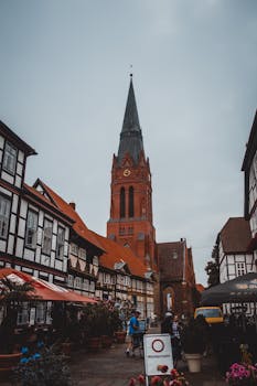 黄昏时分，风景如画的城镇广场上矗立着历史悠久的钟楼和半木结构建筑