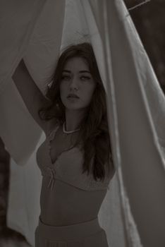 Black and white portrait of a woman in lingerie with soft lighting.