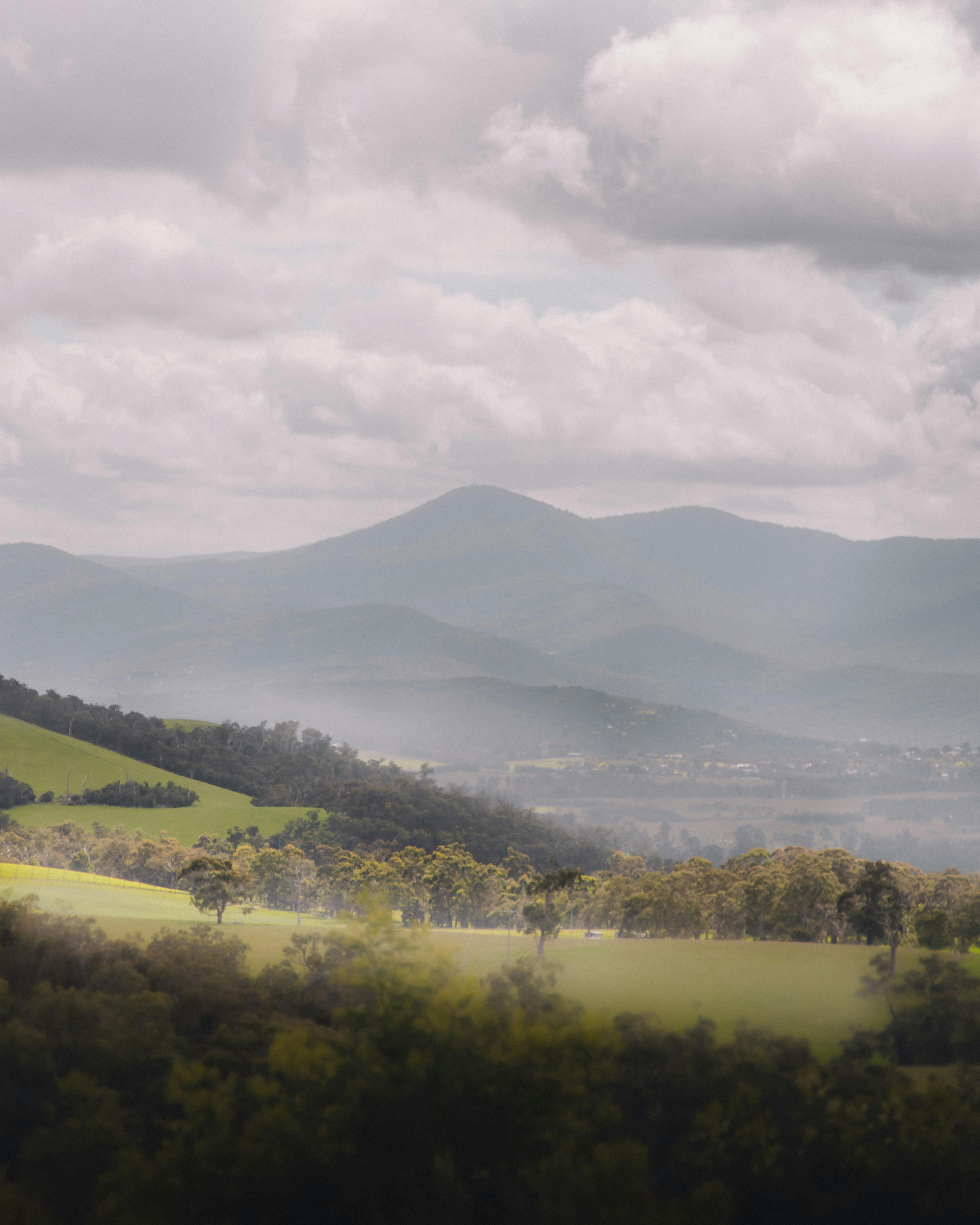 Majestic view of the foggy countryside and mountains near Gruyere, Australia, showcasing natural beauty.