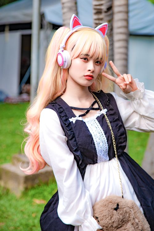 Free Teen girl in cosplay attire and cat ear headphones posing outdoors. Stock Photo