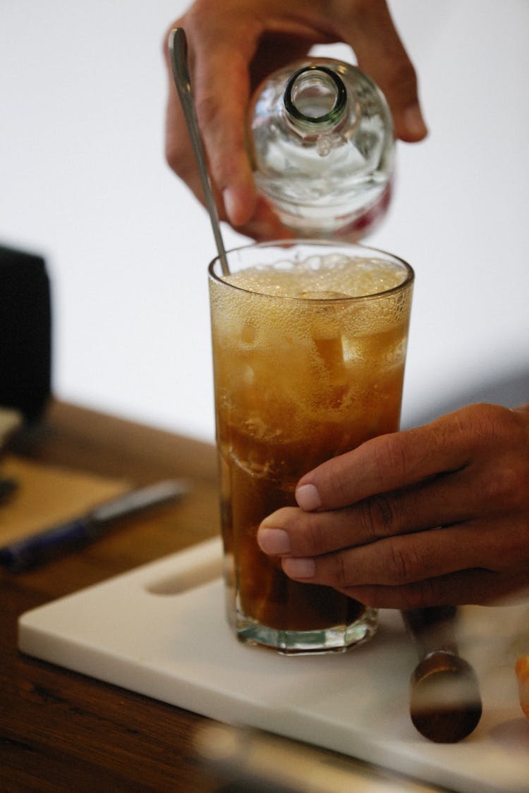 A Person Pouring Water On The Glass