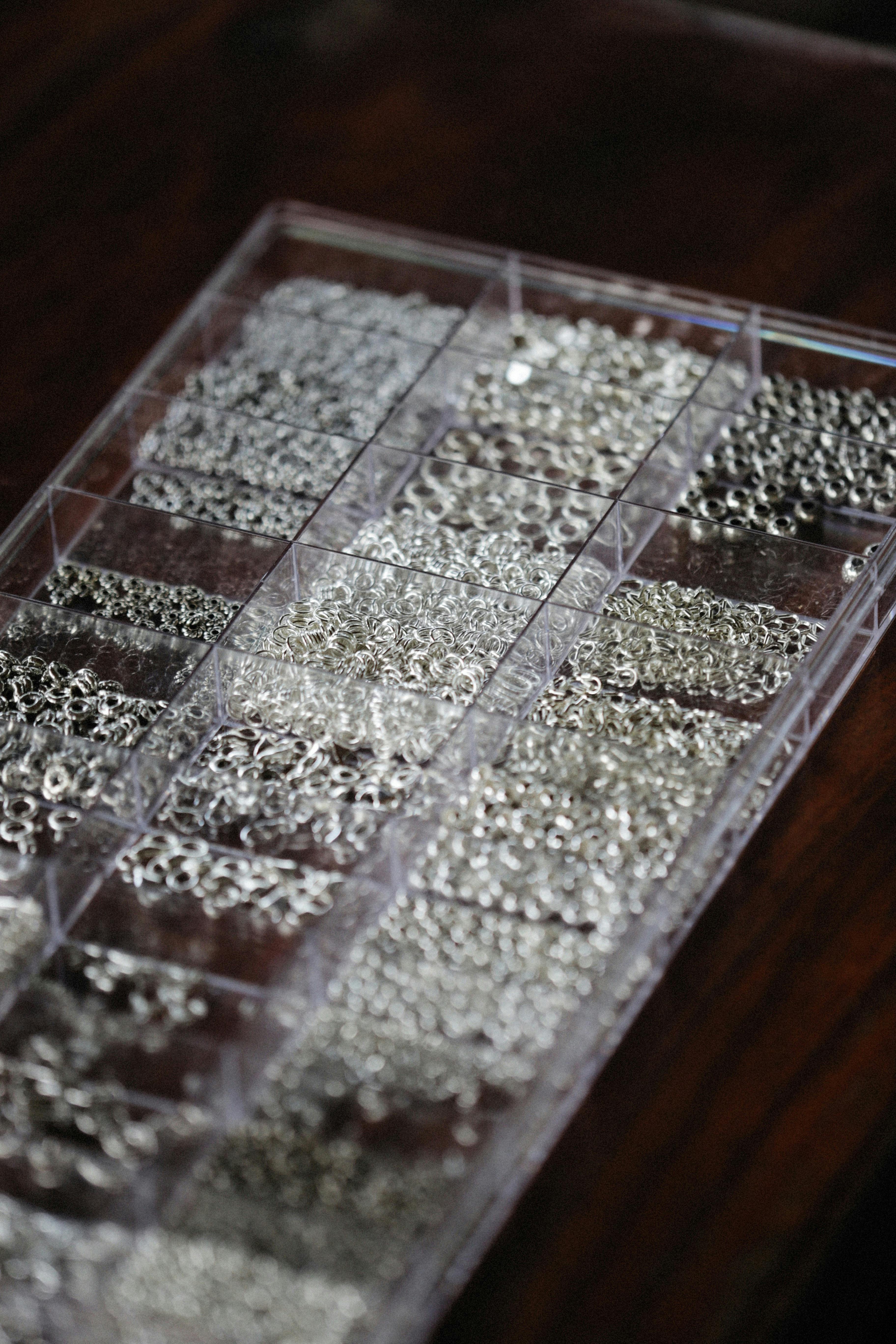 A close-up photo showing various metal components organized in a plastic box.