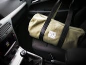 汽车座椅上，时尚的绿色帆布包展现出优雅奢华的旅行格调