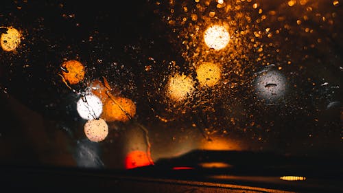 Droplets of Water on the Glass Window Behind Boke Lights