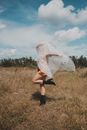 Woman Covered with White Fabric in Field