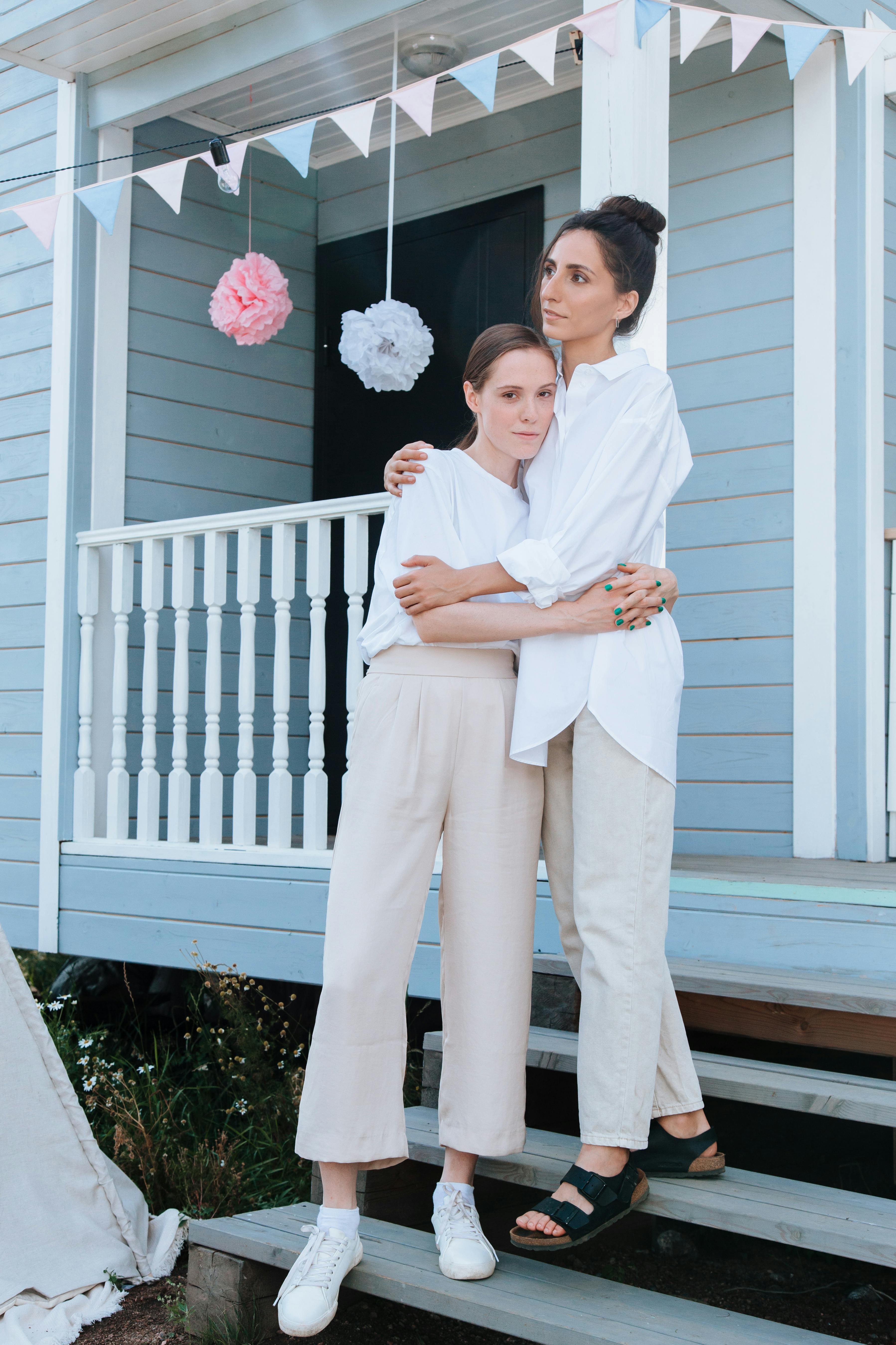 women in white top hugging each other