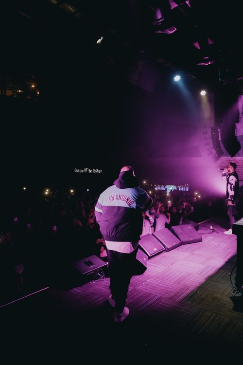 Free Energetic live performance with performers on stage, purple lighting, and engaged audience. Stock Photo