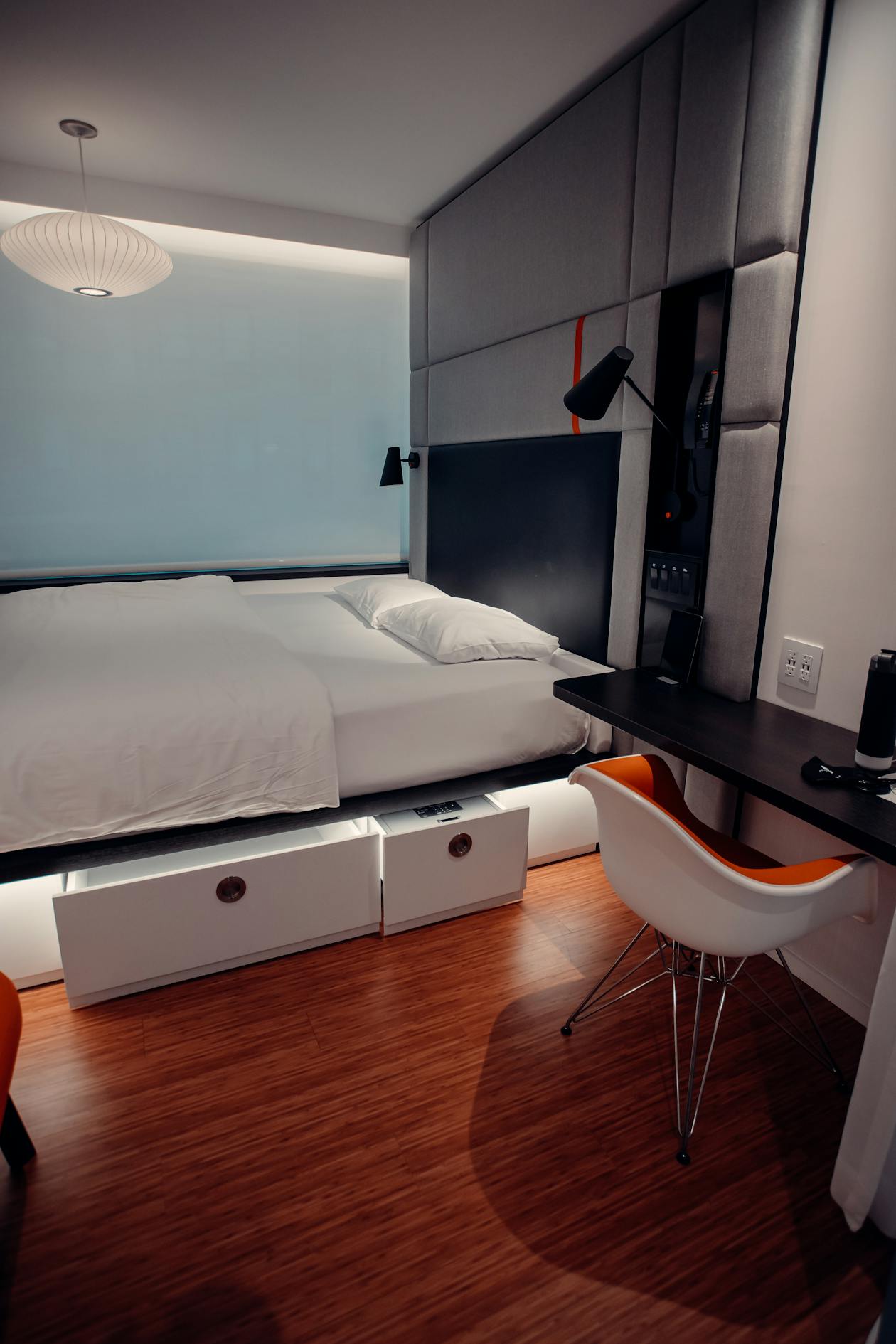 Letto bianco con cassetti contenitore in stanza compatta con scrittoio