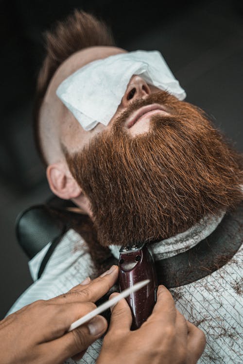 Photo of a Man Getting His Beard Shaved