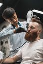 A Barber Drying the Hair of a Customer Using Blow Dryer