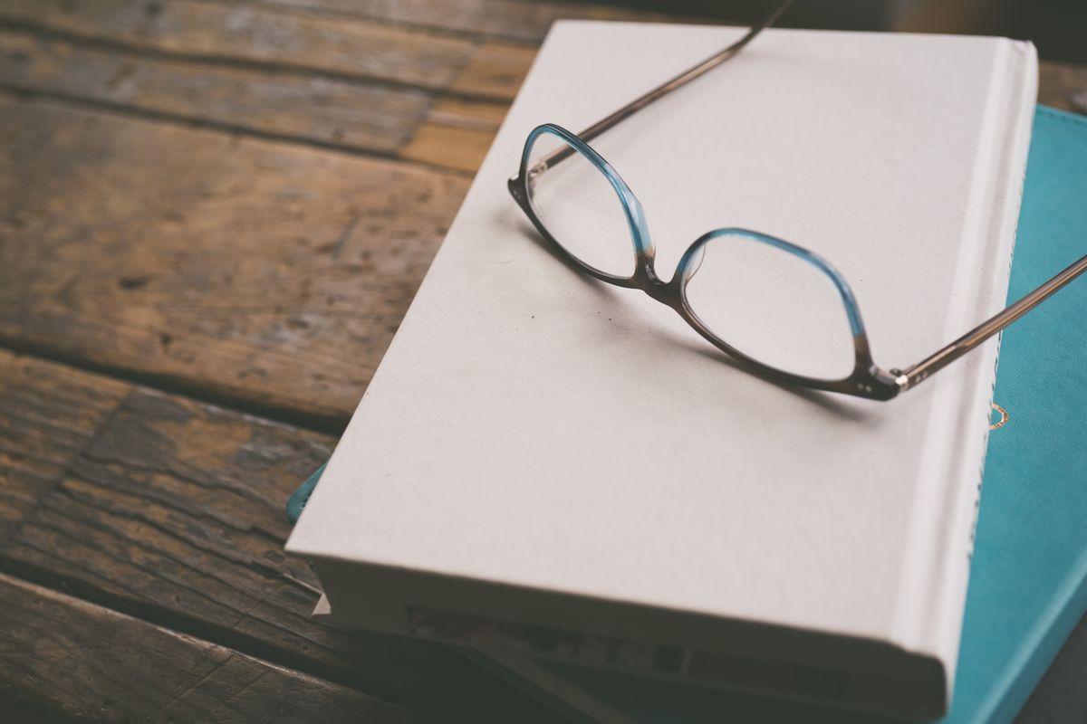 Spectacles resting on an open book - Knowledge, Wisdom and Understanding