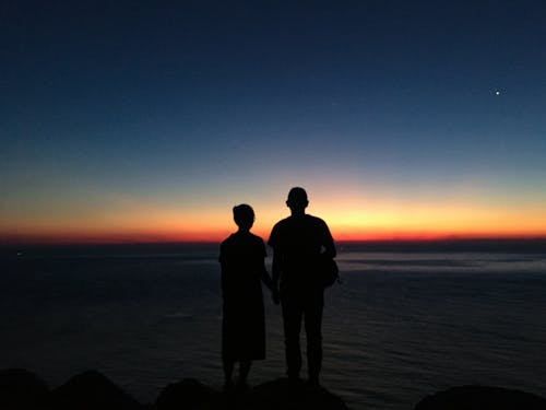 Gratis lagerfoto af glædeligt par, solopgang farver, strand baggrund
