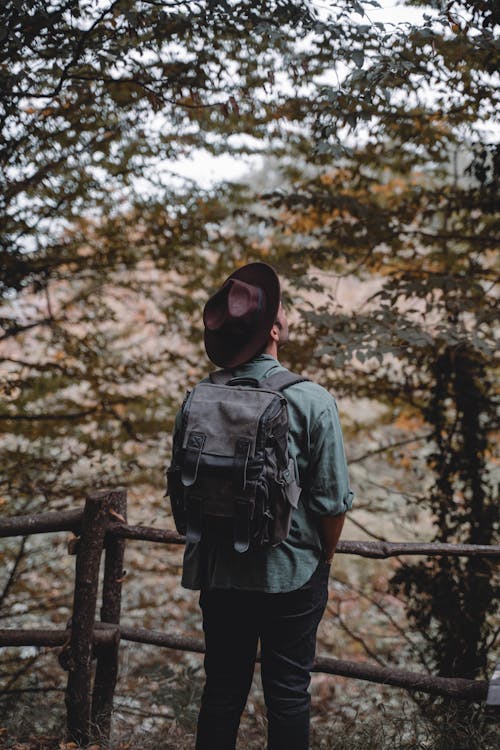 Man Wearing Hat Carrying a Backpack