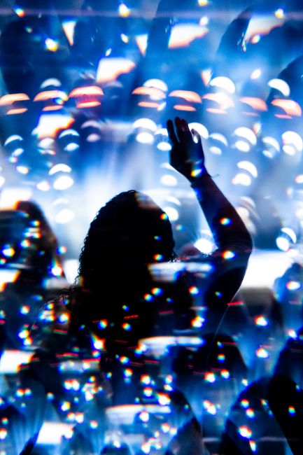 Silhouette of a person dancing with illuminated lights in a vibrant club atmosphere.