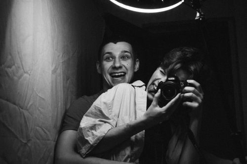 Free A joyful couple capturing a playful moment in a monochrome selfie using a DSLR camera. Stock Photo