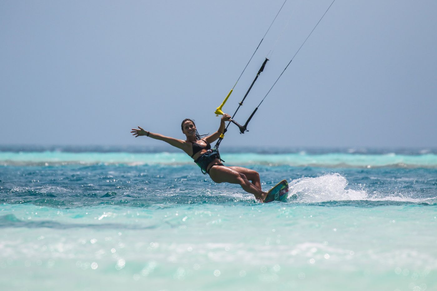 Woman kitesurfing on turquoise water