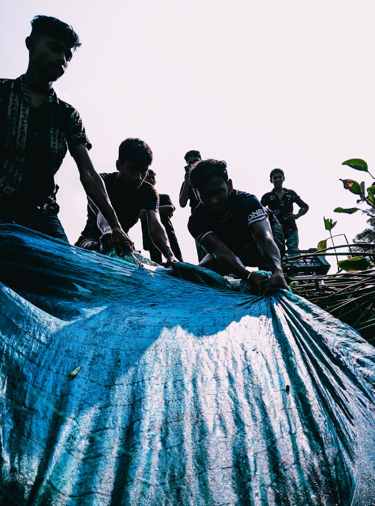 Young Men Pulling Tarp 