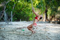 一名身穿红色比基尼的女子在热带海滩上荡秋千，享受夏日的乐趣