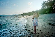 在僻静的海滩上，母亲抱着孩子，这宁静的时刻捕捉到了母性与自然的本质