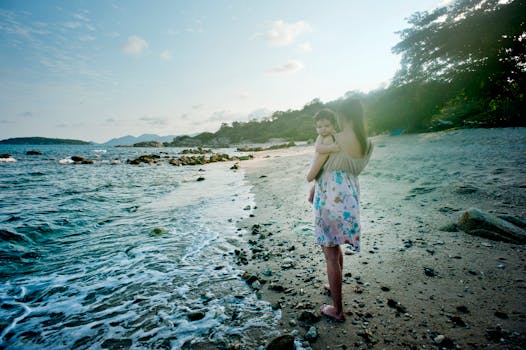 Woman Carrying Baby Beside the Seashore