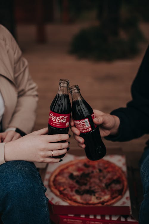 Free People Having a Toast Using the Coca-Cola Bottles They are Holding Stock Photo