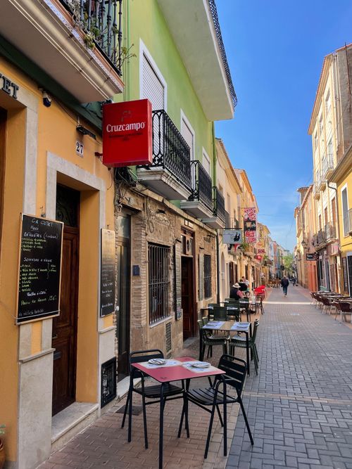 Free Picturesque European alley with vibrant buildings and outdoor cafés lining the street. Stock Photo