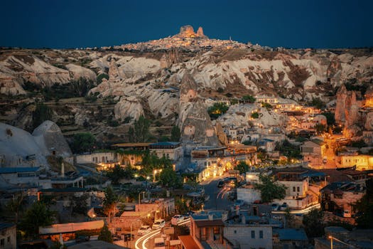 Stunning night view of Göreme in Cappadocia, Turkey, showcasing unique rock formations and lit streets.