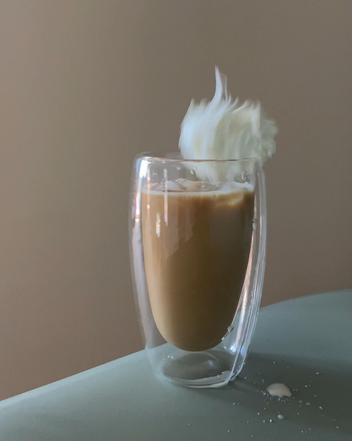 Free Captivating photo of a coffee splash in a transparent glass against a subtle backdrop. Stock Photo