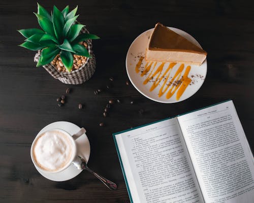 Libro Aperto Vicino Alla Torta E Al Caffè Della Crema Pasticcera