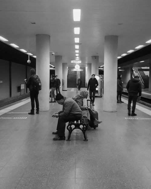 Free Black and white photo of commuters waiting at a subway station. Urban setting. Stock Photo