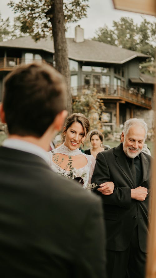 Man in Black Suit Jacket Standing Beside Woman in White Wedding Dress