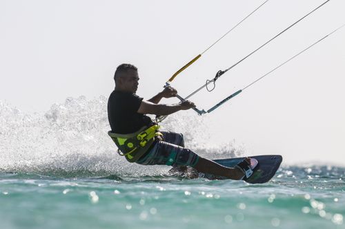 Free Man enjoying an exhilarating kiteboarding experience on clear turquoise water. Stock Photo