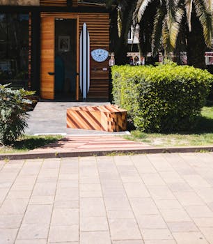 俄罗斯索契一家冲浪店的入口处，阳光明媚，绿植葱郁，还有一条木制长椅