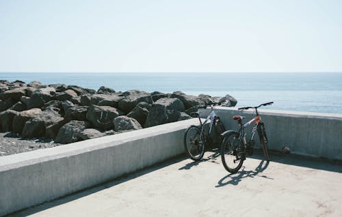회색 콘크리트 벽 뒤에 두 개의 자전거