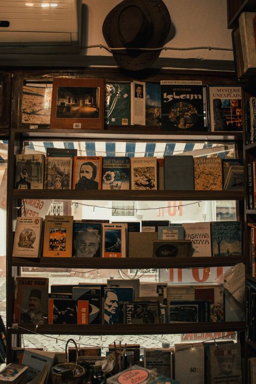 Free A warm and inviting bookstore shelf displaying an assortment of vintage books lined up neatly. Stock Photo