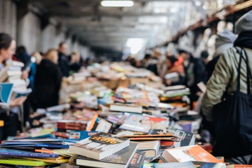 Free A bustling indoor book sale with numerous books and diverse people browsing. Stock Photo