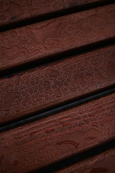Detailed close-up of water droplets on a rich brown wooden texture, emphasizing patterns.