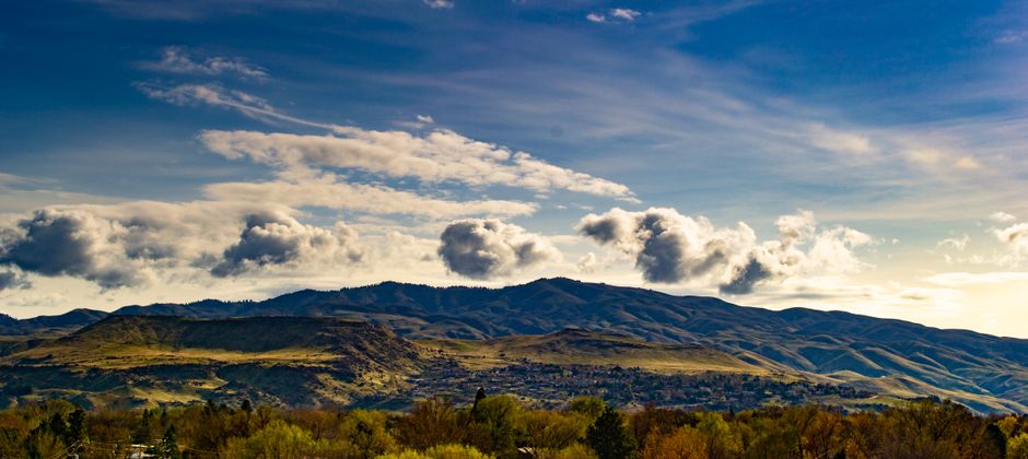 Breathtaking view of mountains under a vibrant blue sky with fluffy clouds.