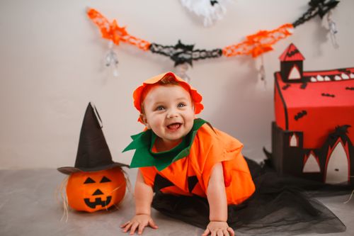 Free Cute baby in pumpkin costume with Halloween decorations indoors. Stock Photo