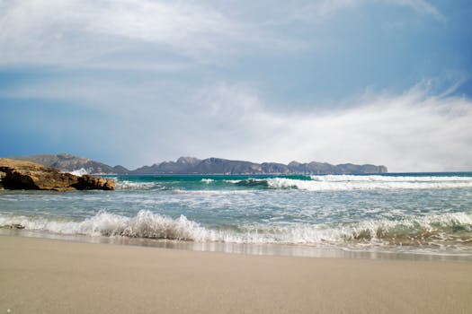 Capture of a serene beach in Illes Balears, Spain with gentle waves and a clear sky.
