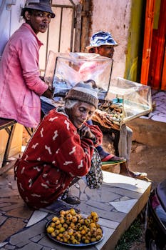 A vibrant street market scene with vendors selling fresh fruits in baskets outdoors.