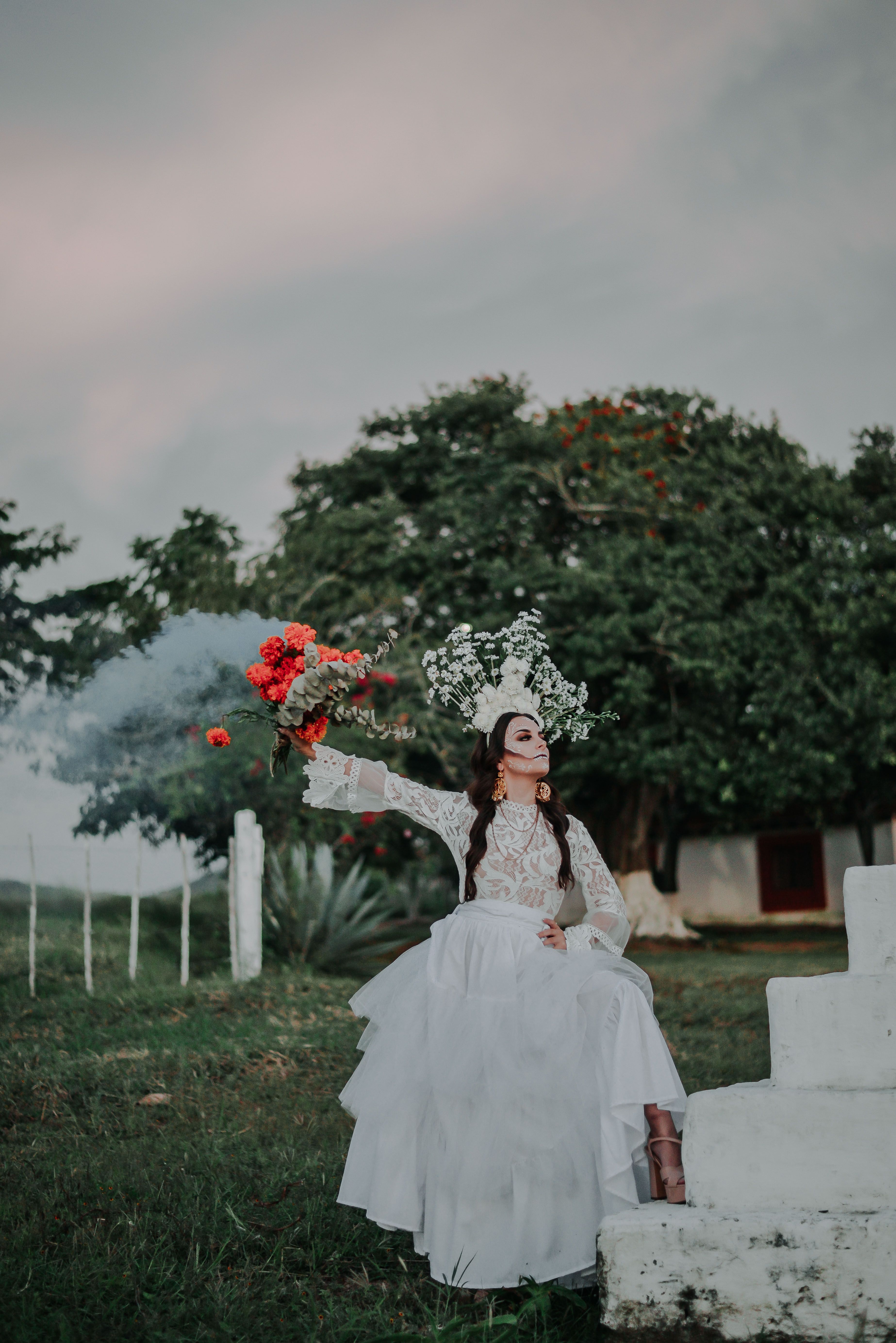 Woman in White Wedding Dress Holding Red Rose Bouquet · Free Stock Photo