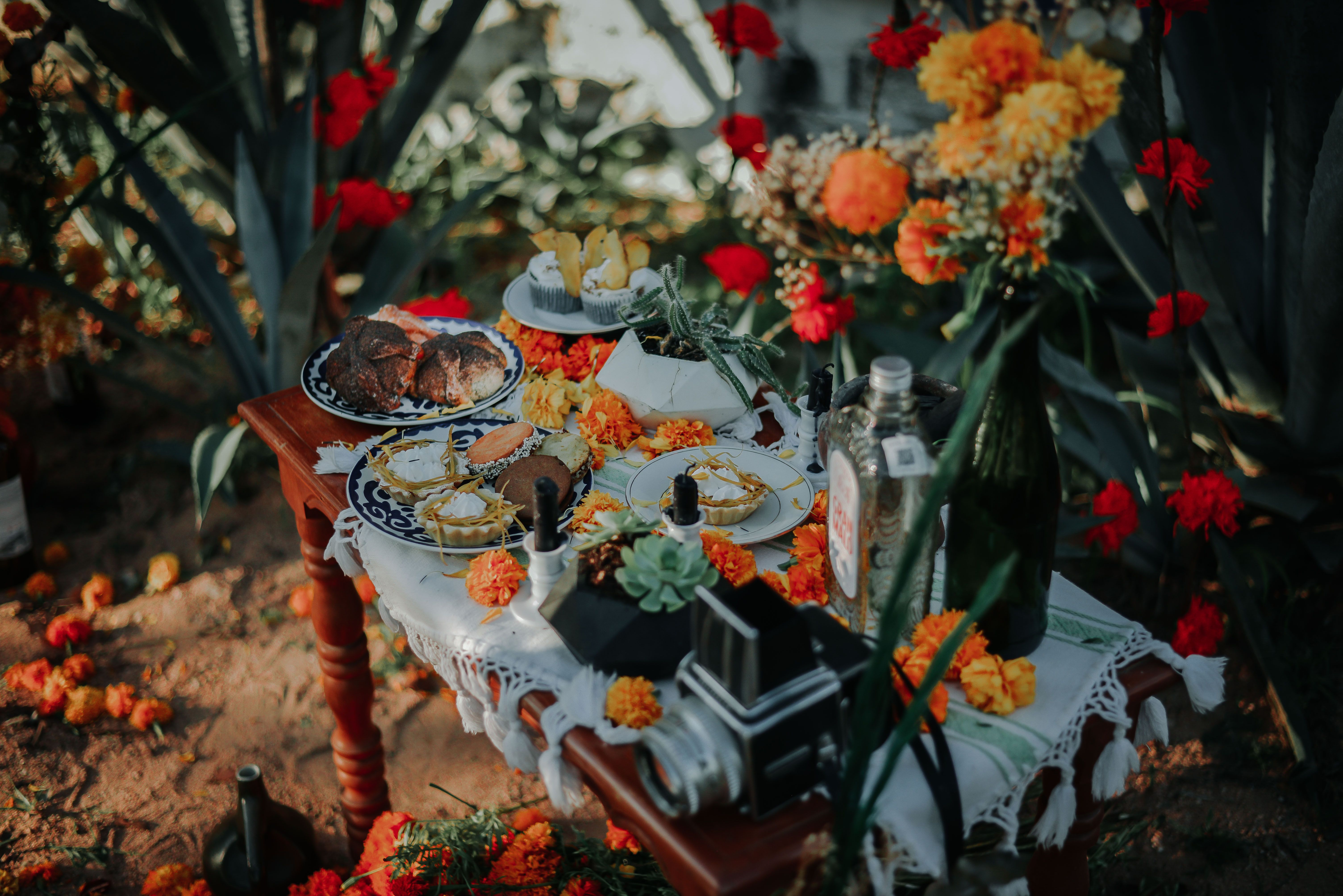 Vibrant outdoor table arrangement adorned with marigolds, food, and camera in Ciudad de México.