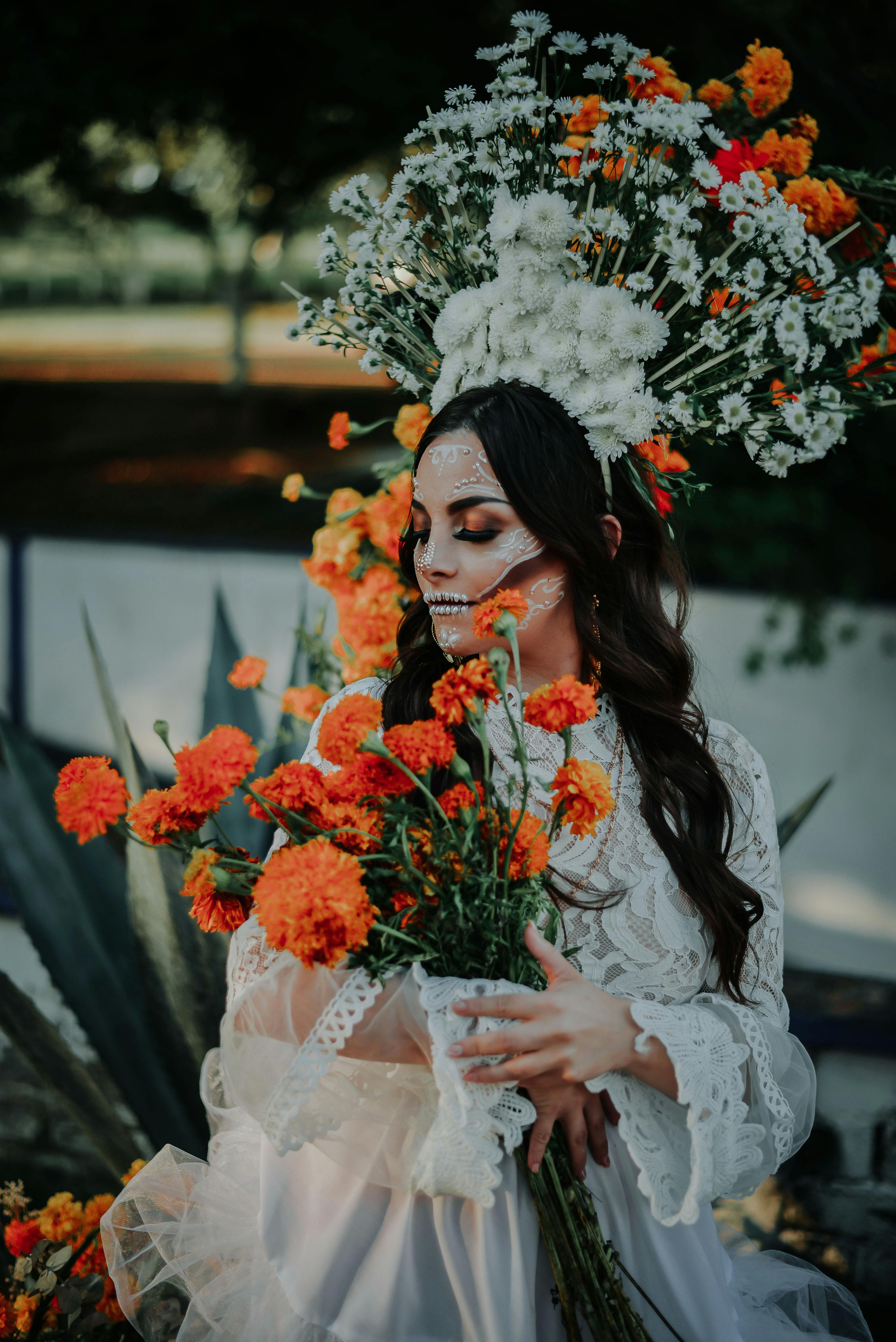 a bride wearing halloween make up and holding flowers