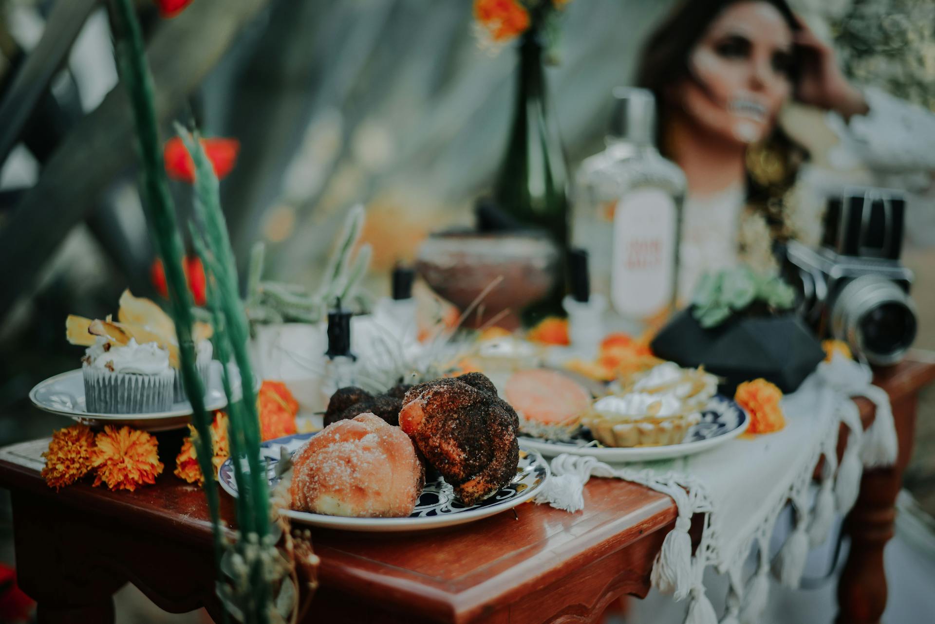 Day of the Dead altar featuring vibrant offerings and a woman in face paint in Ciudad de México.