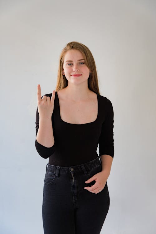 Free Portrait of Smiling Woman Showing Sign Language Stock Photo